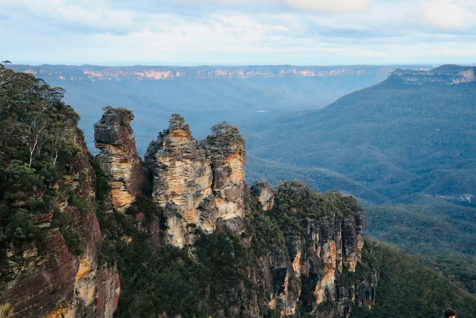 Sandstone cliffs and the Three Sisters rising above the eucalyptus-hazed Jamison Valley in the Blue Mountains