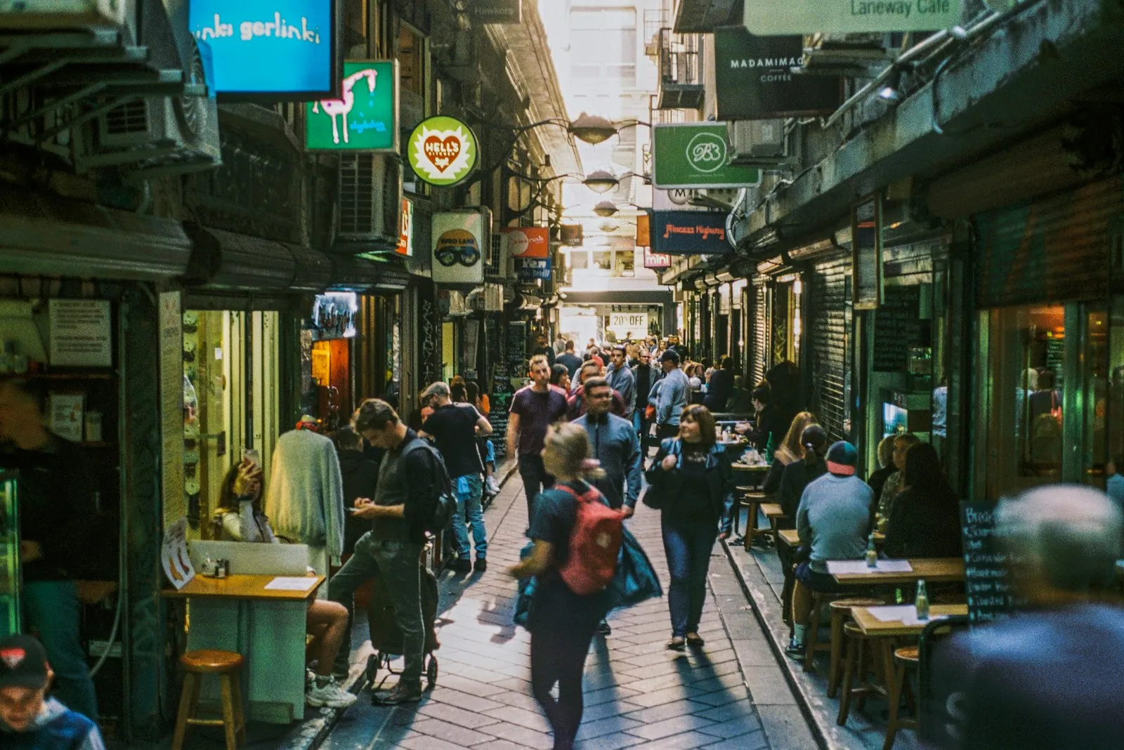 Pedestrians walking through Degraves Street, a narrow Melbourne CBD laneway flanked by tall buildings