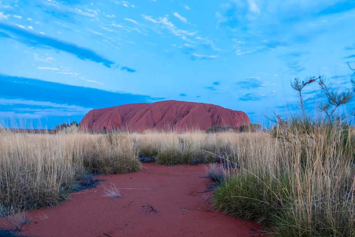 Uluru rock formation in the Australian outback at dusk in the Red Centre