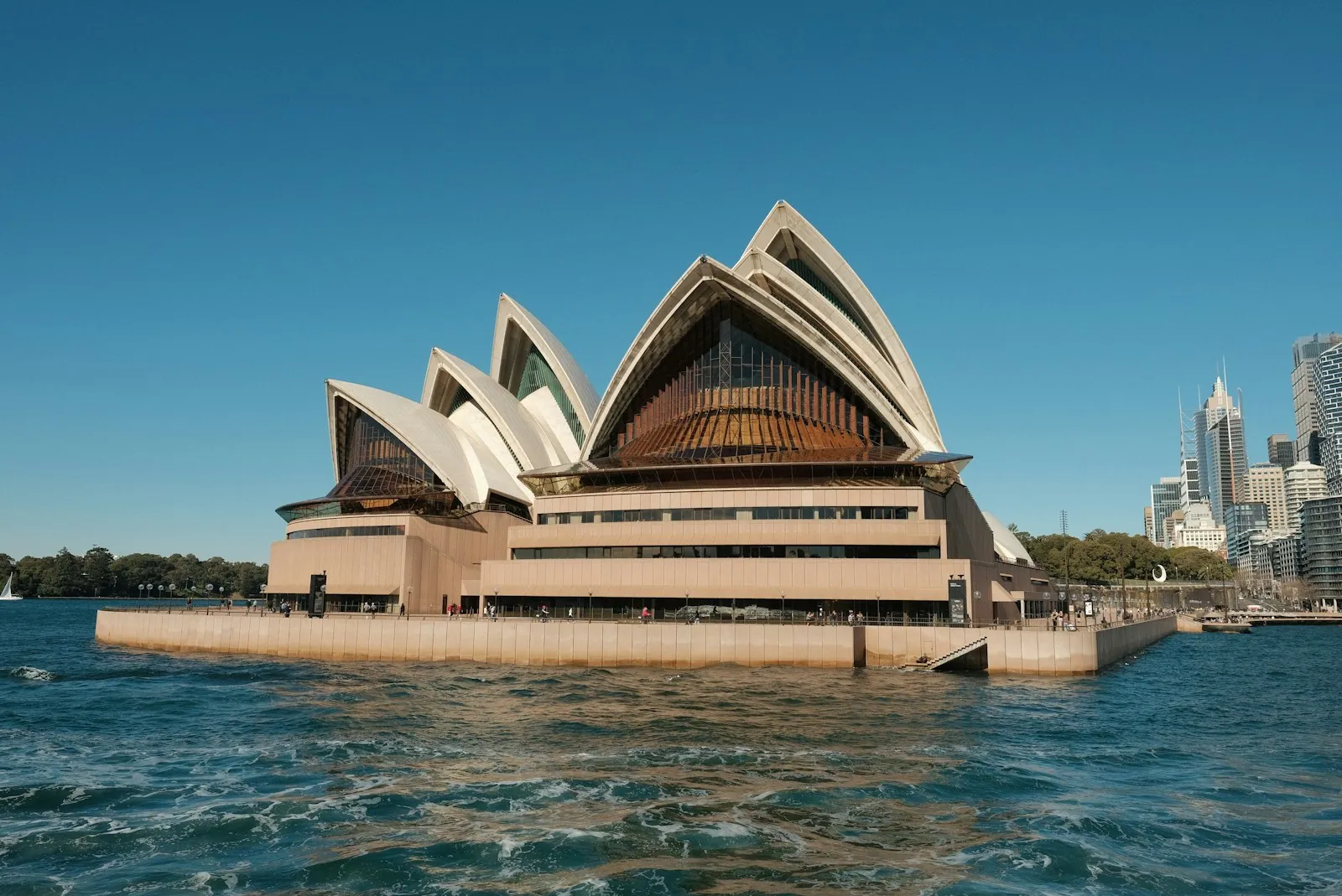 Sydney Opera House sails seen across the harbour water at dusk