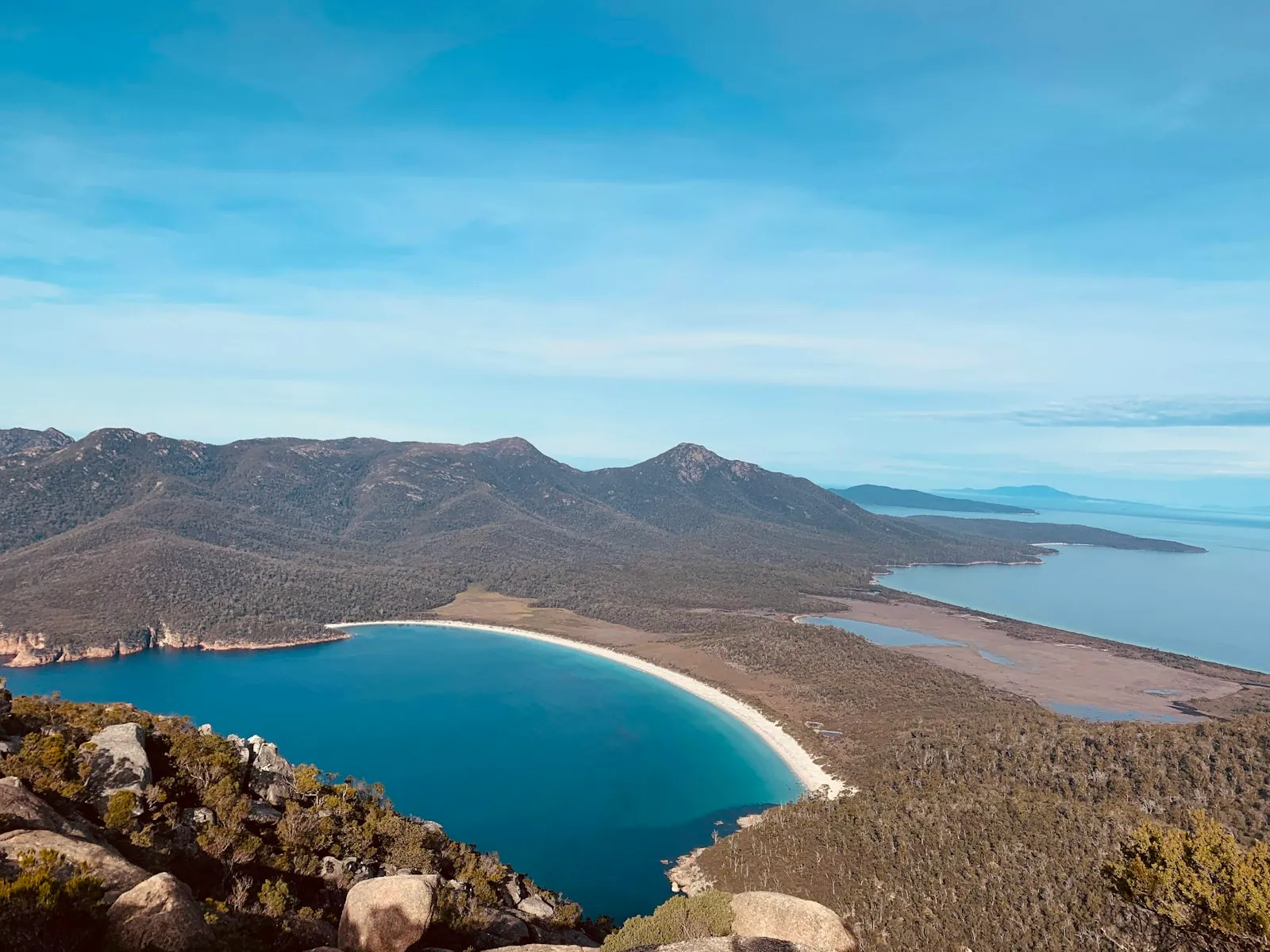 Wineglass Bay crescent of blue water framed by green-clad mountains in Tasmania