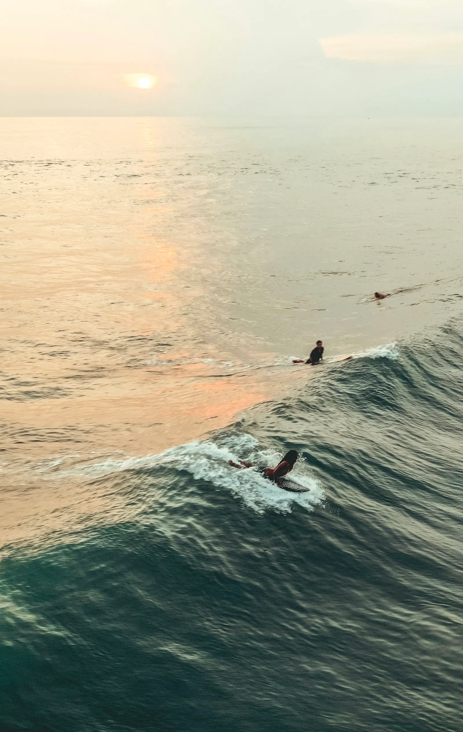 Surfer riding a wave at golden hour on Canggu Beach in Bali
