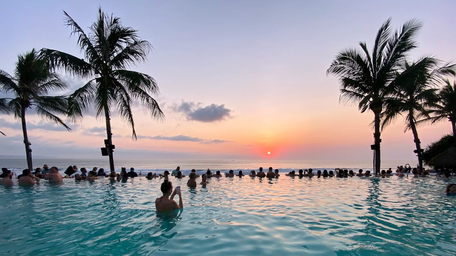 Coconut palms and infinity pool overlooking the ocean at Potato Head Beach Club, Seminyak Bali