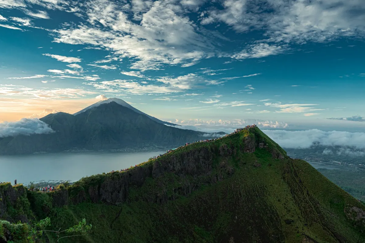 Mt Agung volcano viewed across rice paddies and palm trees in east Bali