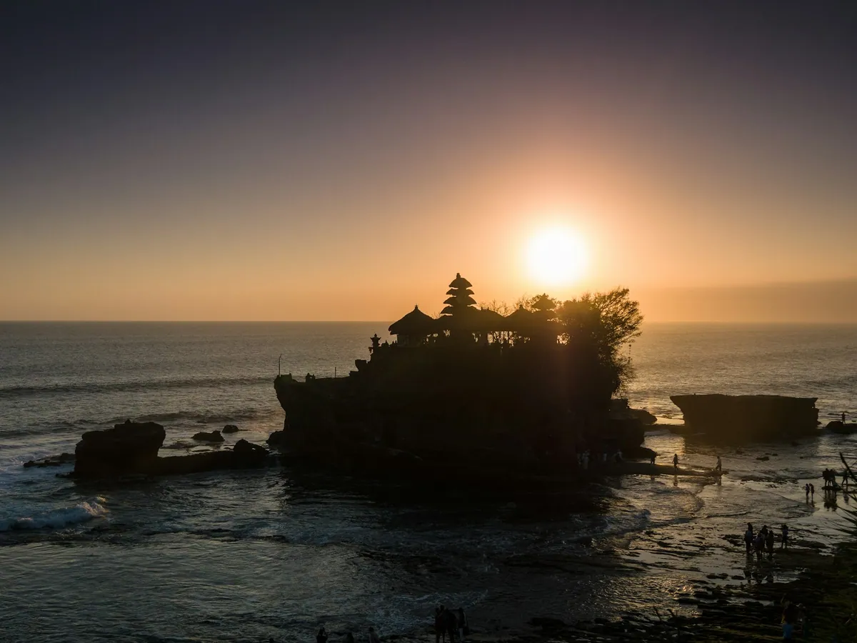 Silhouetted trees on the Tanah Lot island at sunset, Bali
