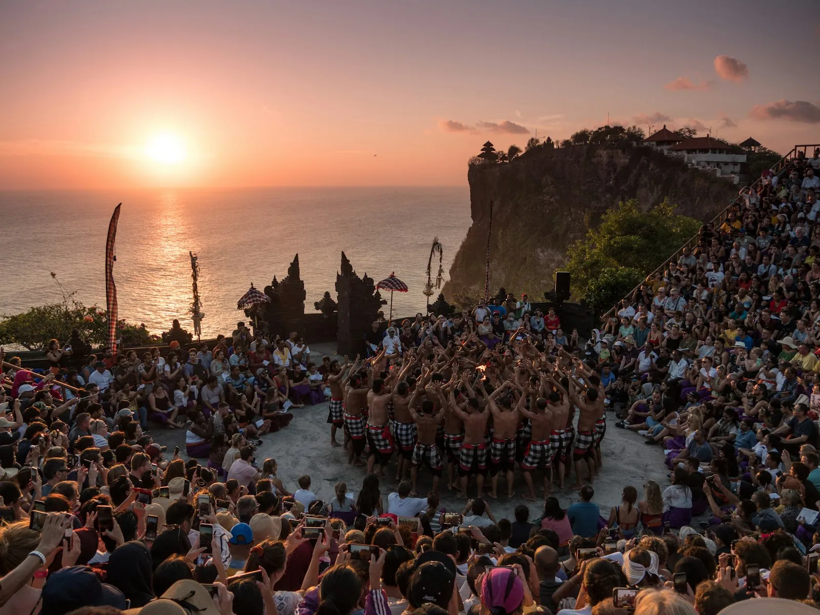 Visitors gathered on the cliff at Pura Luhur Uluwatu temple at sunset, Bali