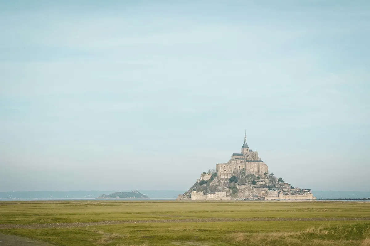 Mont Saint-Michel under blue and white sky, Normandy