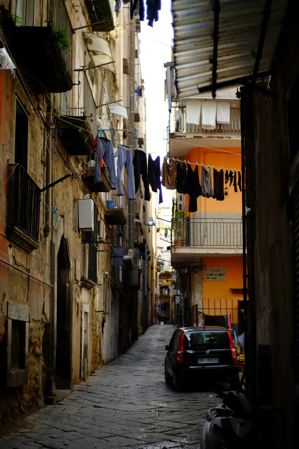 Narrow alleyway in central Naples with weathered buildings