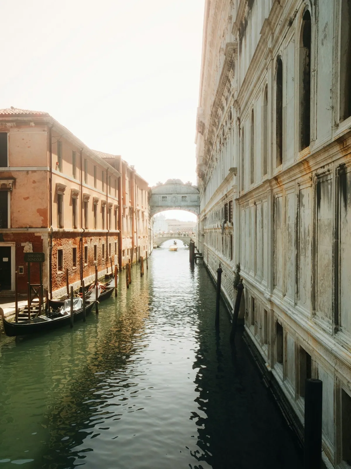 Gondolas docked along a Venetian canal between old buildings