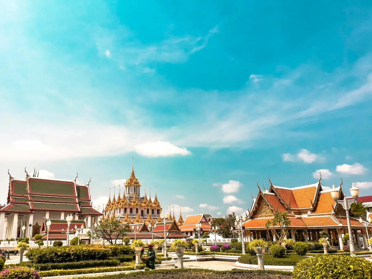 Tuk-tuks lined up outside a Bangkok temple at dusk in Thailand