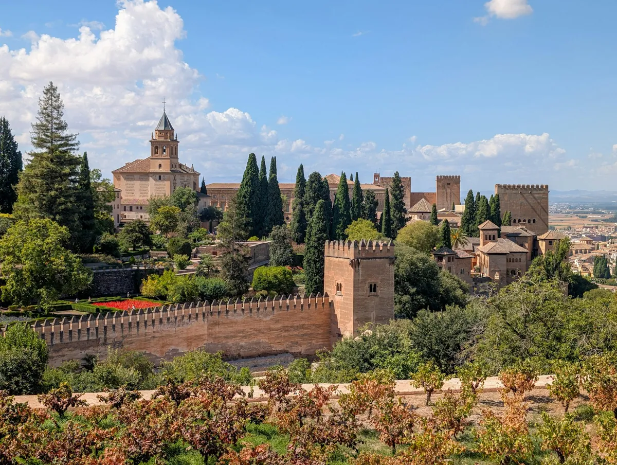 Alhambra palace and gardens with red flowers, Granada