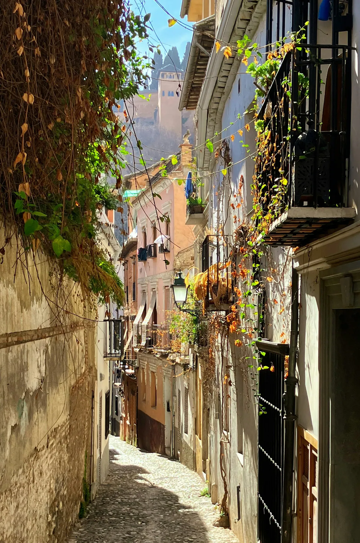 Narrow street with clock tower in the Albaicin neighborhood, Granada